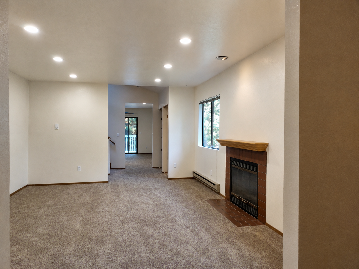 Living room before — original carpet with fireplace