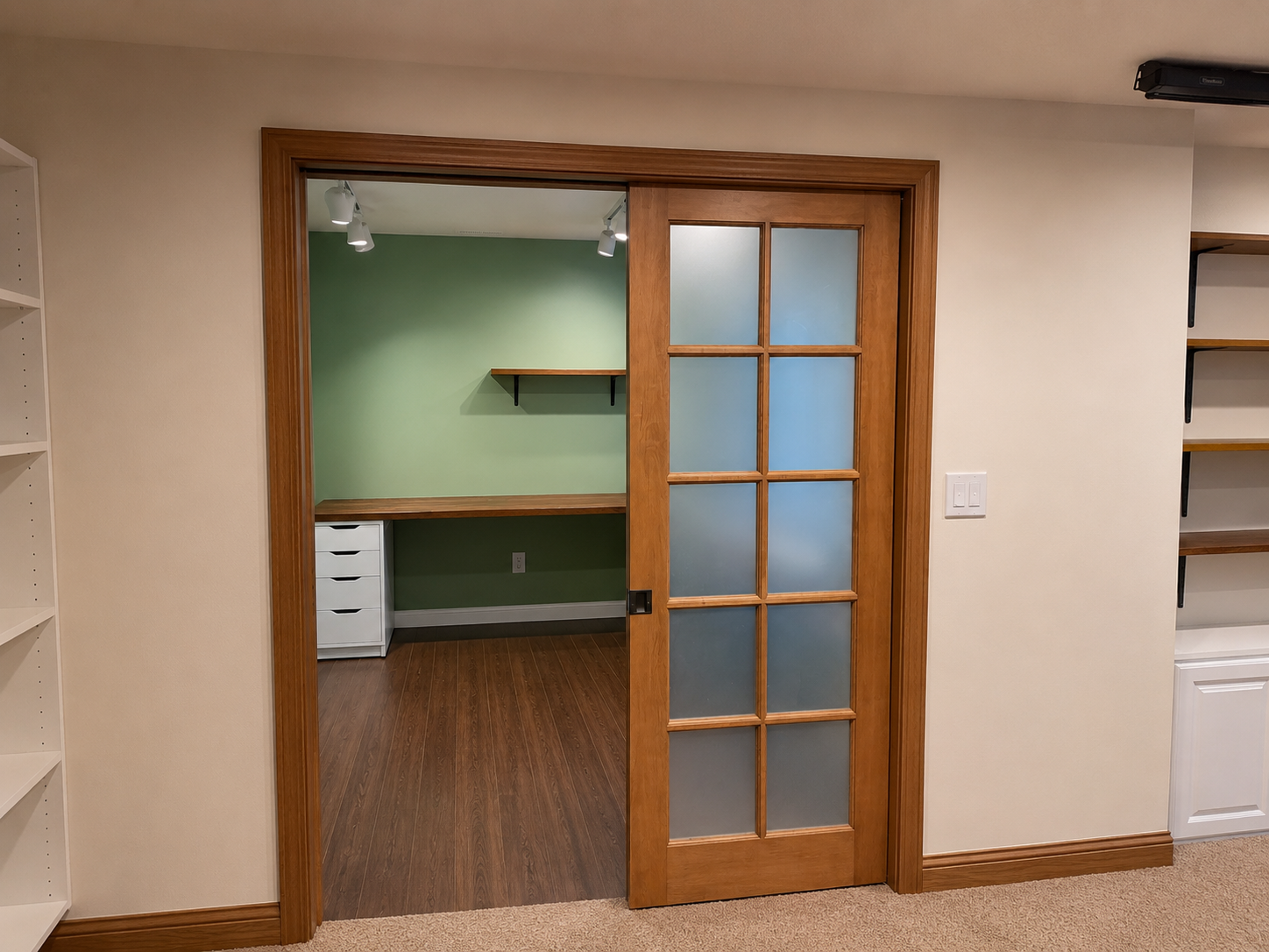 Office after build-out — stained wood framing, French glass door, built-in shelving and cabinet